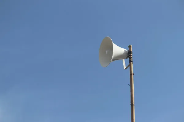 a white bullhorn on top of a wooden pole