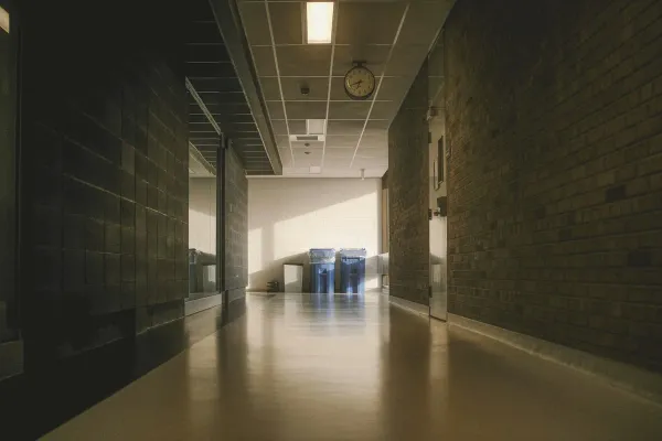 A long hallway with brick walls and bright lighting.