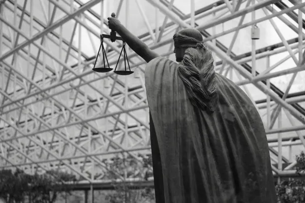 Statue of lady justice holding scales indoors
