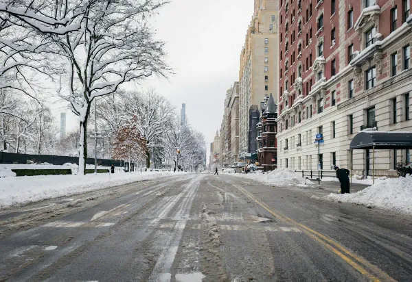 Snow covered street with buildings and trees