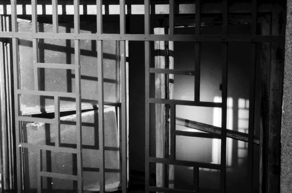 Dark geometric metal gate with strong shadows.